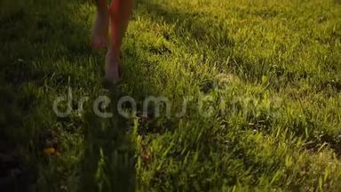 女`的脚在公园的<strong>草地上奔跑</strong>，赤脚。